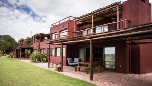 um edifício vermelho com um banco fora dele em Pueblo Nativo Resort Golf & Spa em La Cumbre