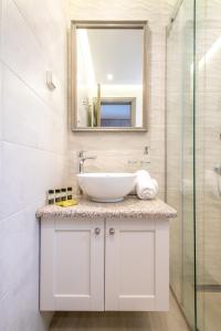 a bathroom with a sink and a mirror at Amigdalies in Myrina