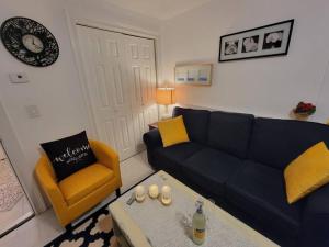 a living room with a blue couch and a yellow chair at Comfy and Chic Boston Apartment! in Boston