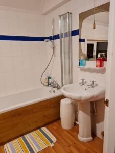 a bathroom with a sink and a bath tub at The Hillock in Uplawmoor