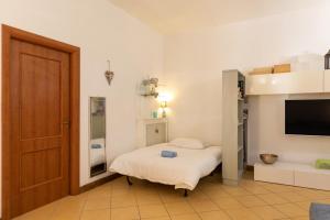 Cette petite chambre comprend un lit et une télévision. dans l'établissement COLORED HOUSE UNTIL 7 PEOPLE ABOVE SqPLEBISCITO, à Naples