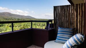 a bed with a pillow on a balcony with a view at Pueblo Nativo Resort Golf & Spa in La Cumbre