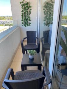 a balcony with two chairs and a table with a plant at Departamentos Apart Hotel Chillán Center SPA in Chillán