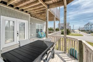 un patio avec une table et des chaises sur une terrasse dans l'établissement Spectacular sunsets on the sound - only one block from the beach, à North Topsail Beach