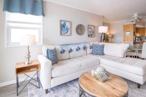 Una sala de estar con un sofá blanco y una mesa. en Pelican Watch 807 Oceanfront Balcony with indoor and outdoor Pool, en Carolina Beach