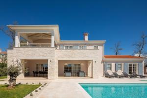 a villa with a swimming pool and a house at Villa Harmony by ILC (Istria Luxury Collection) in Brtonigla