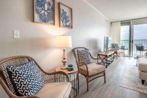 sala de estar con sillas y mesa con lámpara en Pelican Watch 807 Oceanfront Balcony with indoor and outdoor Pool, en Carolina Beach