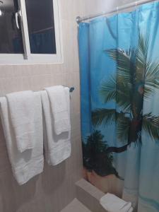a bathroom with a shower curtain with a palm tree at Hermoso Apartamento ideal familia in Pantoja