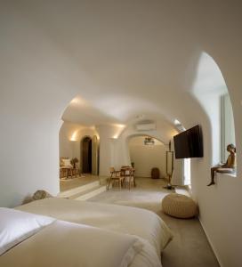 a bedroom with a bed and a living room at Oia Treasures Art Suites in Oia