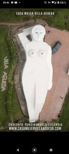 Una gran estatua blanca con dos caras. en Casa Mujer Villa Agueda, en Chocontá