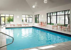 a swimming pool with blue water in a building at Holiday Inn & Suites Boston Peabody, an IHG Hotel in Peabody