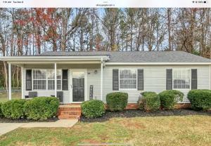 uma casa branca com arbustos à frente em Majestic Escape em Charlotte