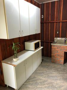 a kitchen with a microwave sitting on top of a counter at Pousada do Salto Ventoso / Serra Gaúcha Casa 1 in Farroupilha