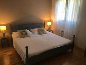 een slaapkamer met een bed met witte lakens en een raam bij Villa Lorena in Sutivan