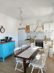 een keuken met een tafel en stoelen en een koelkast bij Villa Lorena in Sutivan