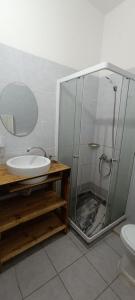 a bathroom with a shower and a sink and a toilet at Kaza Jindung in Mindelo
