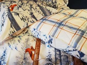 a bed with a blue and white quilt with deer on it at Moulin de Schwabwiller in Schwabwiller