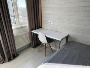 a bedroom with a desk and a chair next to a window at Business Double Room Lux Apartment in the Center in Chişinău