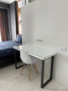 a desk with a chair in a room with a bed at Business Double Room Lux Apartment in the Center in Chişinău