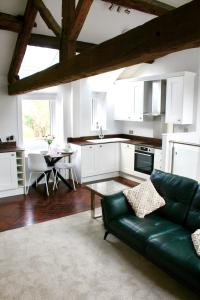salon z zieloną kanapą i stołem w obiekcie Pheasants Crossing - luxurious and cozy cottage in peaceful rural location w mieście Almondbury