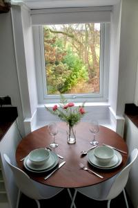a table with plates and glasses and a window at Pheasants Crossing - luxurious and cozy cottage in peaceful rural location in Almondbury