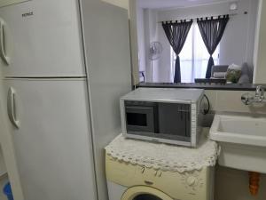 a kitchen with a microwave and a sink and a refrigerator at Departamento en Santa Fe in Santa Fe