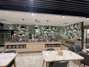 a restaurant with tables and chairs and a kitchen at Benz Hotel in Zhongli