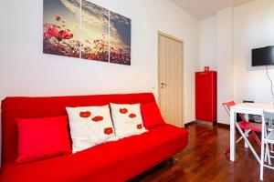 een rode bank in een woonkamer met een tafel bij BidiBo apartment, in centro comodo alla Stazione in Bologna