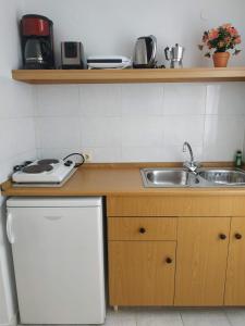 a kitchen with a sink and a stove and a sink at BELLA CASA KOLYMPIA in Kolimbia