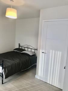 a bedroom with a bed and a large door at 27 William Jessop Way Bristol BS13 0RL in Whitchurch