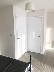a bedroom with white walls and white doors at 27 William Jessop Way Bristol BS13 0RL in Whitchurch