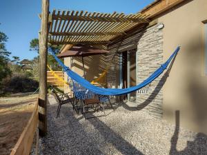 a hammock on the side of a house at Villas Laura in Punta Del Diablo