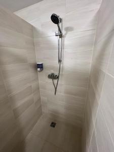 a shower with a shower head in a bathroom at Hostel H18 in Bardejov