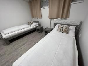 a bedroom with a large white bed and a couch at Hostel H18 in Bardejov