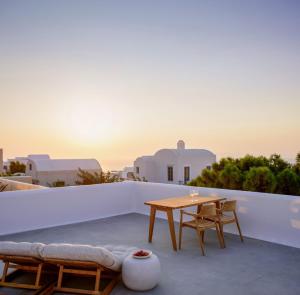 a patio with a table and chairs on a roof at Oia Treasures Art Suites in Oia