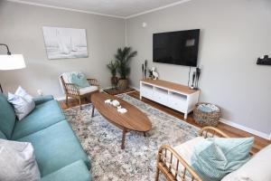 a living room with a couch and a table and a tv at Adorable 2-bedroom guest house with free parking in Galveston