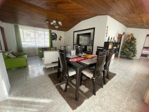 a dining room with a table and chairs and a christmas tree at CASA CAMPESTRE VILLA JULIA in Quetame