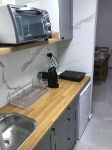 a kitchen with a sink and a microwave on a counter at Sima Suite 2 in Ashdod