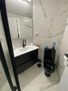 a bathroom with a black toilet and a sink at Sima Suite 2 in Ashdod