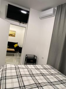 een slaapkamer met een bed en een flatscreen-tv bij Sima Suite 2 in Ashdod