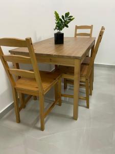 a wooden table with two chairs and a potted plant at Sima Suite 2 in Ashdod