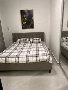 a bedroom with a bed with a plaid comforter at Sima Suite 6 in Ashdod