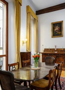 uma sala de jantar com uma mesa de madeira com flores em Piazza DUOMO - Antico Appartamento dell'800 em Milão