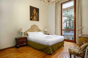 um quarto com uma cama grande e uma janela em Piazza DUOMO - Antico Appartamento dell'800 em Milão