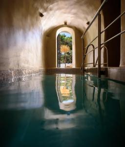 a pool of water in a building with a window at Oia Treasures Art Suites in Oia