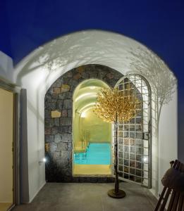 a room with a pool and a stone wall at Oia Treasures Art Suites in Oia
