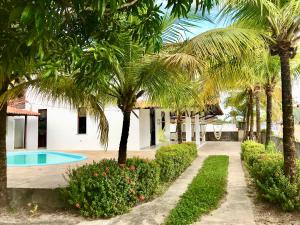 a villa with a swimming pool and palm trees at Casa com piscina no Maçarico - Casa Água Viva in Salinópolis