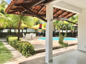a patio with a hammock and a pool at Casa com piscina no Maçarico - Casa Água Viva in Salinópolis +20 photos