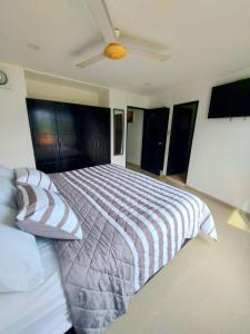 a bedroom with a bed and a ceiling fan at The Cantamar Beach Hostel in Santa Marta