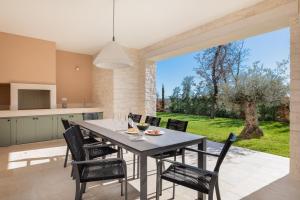 - une cuisine et une salle à manger avec une table et des chaises dans l'établissement Villa Iris by ILC (Istria Luxury Collection), à Brtonigla